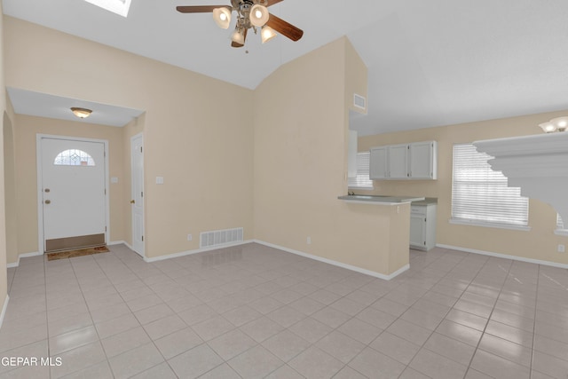 7341 Desierto Rojo Ct, El Paso, TX 79912 - interior space featuring baseboards, visible vents, lofted ceiling, ceiling fan, and light tile patterned floors