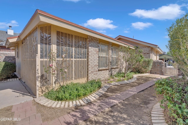 7341 Desierto Rojo Ct, El Paso, TX 79912 - view of side of home with a gate and brick siding