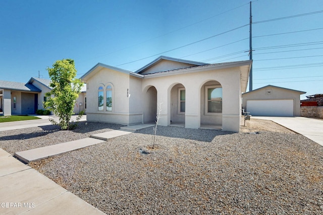 ranch-style home with an outbuilding, concrete driveway, a garage, and stucco siding