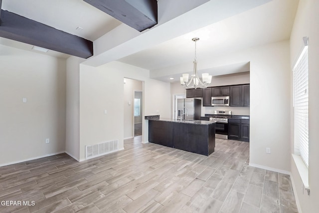kitchen with light wood-type flooring, appliances with stainless steel finishes, a notable chandelier, and visible vents