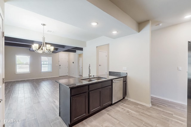 kitchen featuring dark stone counters, an inviting chandelier, stainless steel dishwasher, dark brown cabinetry, and a sink