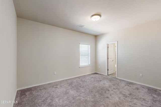 empty room featuring light carpet, baseboards, and visible vents