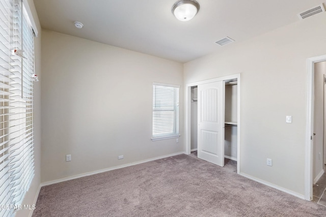 unfurnished bedroom featuring visible vents, baseboards, carpet flooring, and a closet