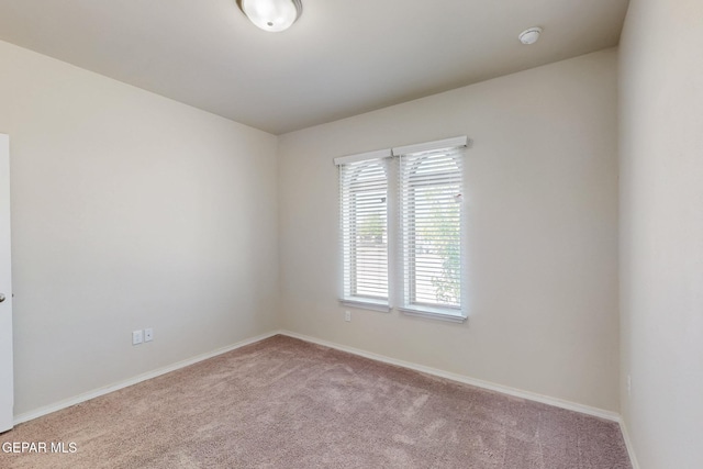 unfurnished room featuring baseboards and carpet