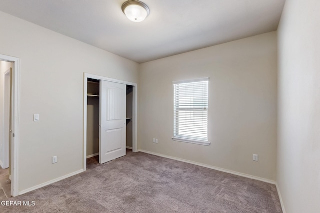 unfurnished bedroom featuring a closet, baseboards, and carpet