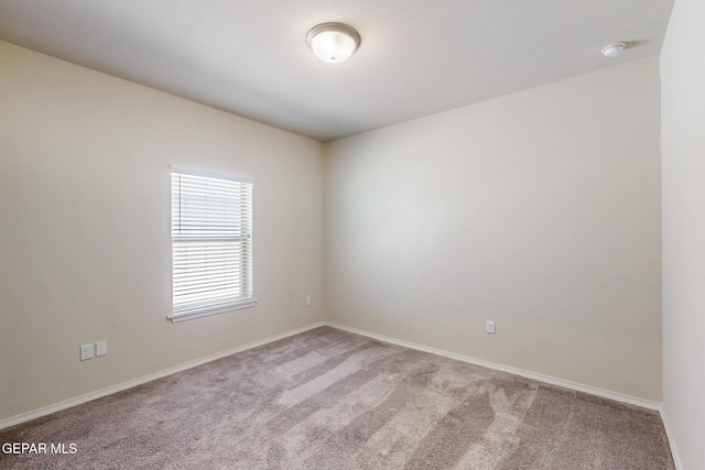 empty room featuring carpet flooring and baseboards