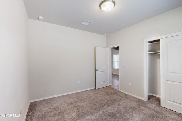 unfurnished bedroom with a closet, baseboards, carpet, and visible vents