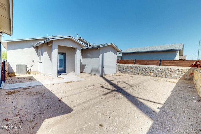 exterior space with cooling unit, a patio area, stucco siding, and fence