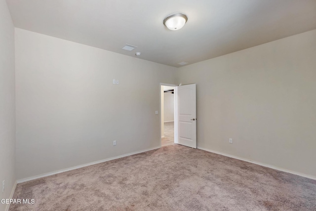 empty room featuring carpet flooring, visible vents, and baseboards