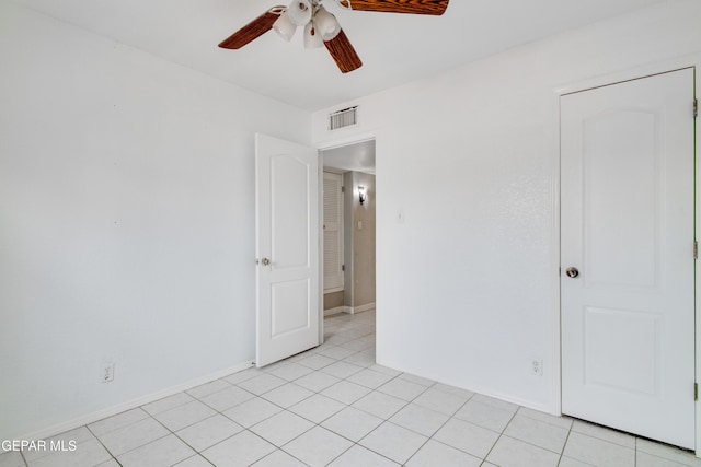 unfurnished bedroom with light tile patterned floors, baseboards, a ceiling fan, and visible vents