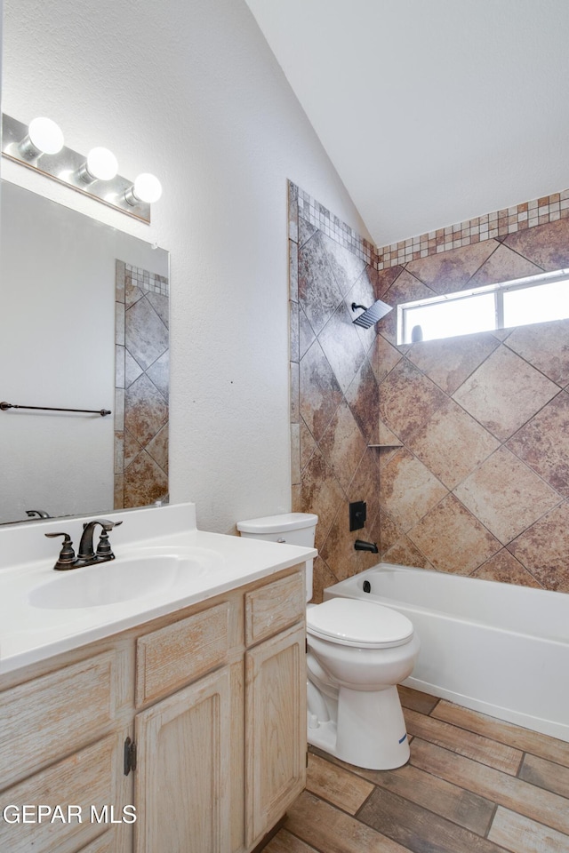 full bath with vanity, toilet, shower / bathtub combination, lofted ceiling, and wood finished floors
