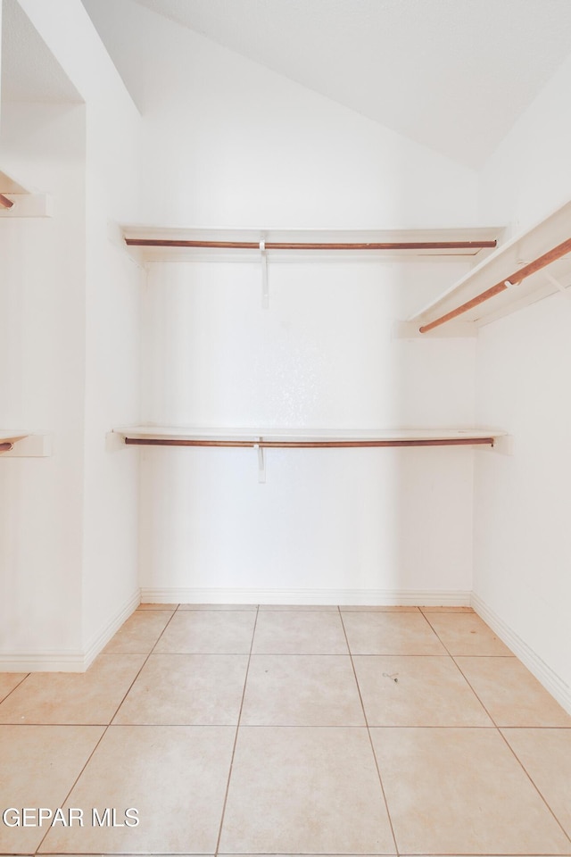walk in closet featuring tile patterned flooring and lofted ceiling