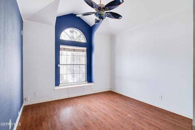 spare room featuring wood finished floors, ceiling fan, baseboards, and lofted ceiling
