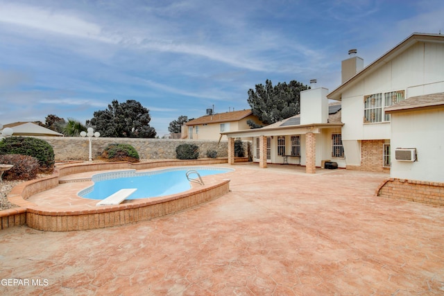 view of swimming pool with a fenced backyard, a fenced in pool, a patio, and a wall unit AC