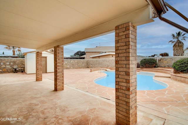 view of swimming pool featuring a patio, an outbuilding, a fenced backyard, and a fenced in pool
