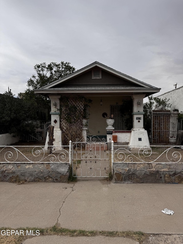view of front of house with a fenced front yard and a gate