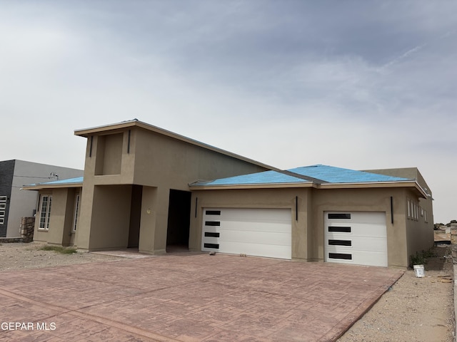 11345 Ardelle Ave, El Paso, TX 79936 - contemporary house featuring an attached garage, decorative driveway, and stucco siding