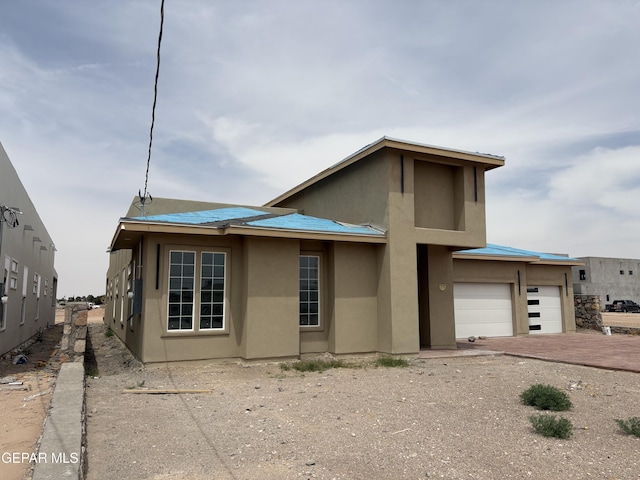 11345 Ardelle Ave, El Paso, TX 79936 - view of front of home featuring a garage, driveway, and stucco siding