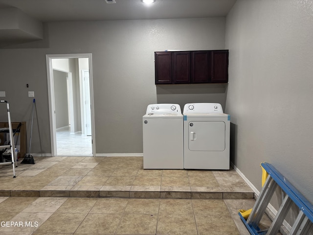 laundry area featuring independent washer and dryer, baseboards, and cabinet space