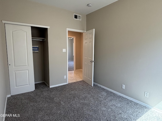 unfurnished bedroom with visible vents, carpet, baseboards, and a closet