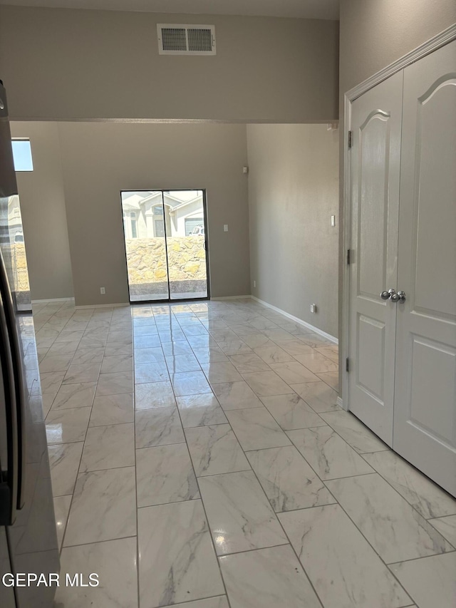 spare room featuring visible vents, marble finish floor, and baseboards