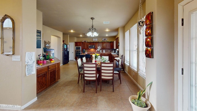 7350 La Casa Way, Canutillo, TX 79835 - dining space featuring visible vents, arched walkways, light tile patterned floors, baseboards, and a chandelier