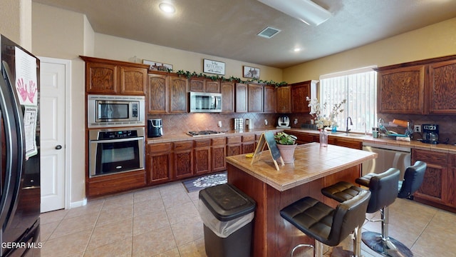 7350 La Casa Way, Canutillo, TX 79835 - kitchen featuring visible vents, tile countertops, tasteful backsplash, a sink, and appliances with stainless steel finishes