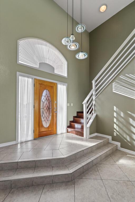 5628 Buckley Dr, El Paso, TX 79912 - tiled foyer entrance with a chandelier, a towering ceiling, baseboards, and stairway