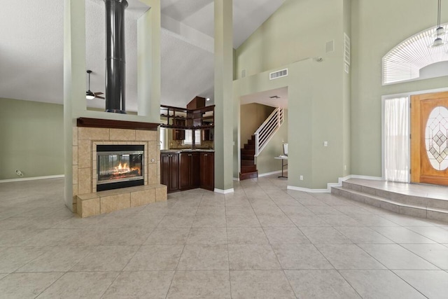 5628 Buckley Dr, El Paso, TX 79912 - entrance foyer with high vaulted ceiling, light tile patterned floors, visible vents, and a tile fireplace