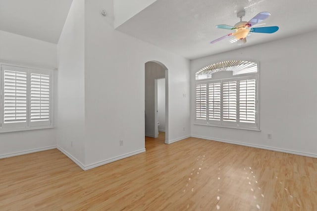 5628 Buckley Dr, El Paso, TX 79912 - unfurnished room featuring arched walkways, ceiling fan, baseboards, and wood finished floors