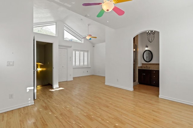 5628 Buckley Dr, El Paso, TX 79912 - unfurnished living room featuring baseboards, light wood-style floors, lofted ceiling, arched walkways, and ceiling fan