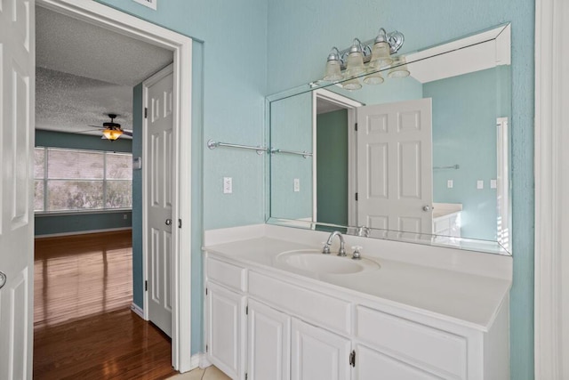 5628 Buckley Dr, El Paso, TX 79912 - bathroom with ceiling fan, a textured ceiling, vanity, wood finished floors, and baseboards