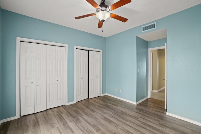 5628 Buckley Dr, El Paso, TX 79912 - unfurnished bedroom with visible vents, baseboards, multiple closets, and wood finished floors