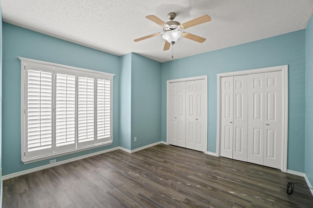5628 Buckley Dr, El Paso, TX 79912 - unfurnished bedroom featuring baseboards, a textured ceiling, two closets, and wood finished floors
