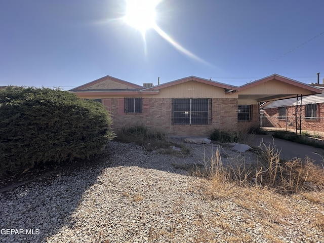 view of side of property featuring brick siding and a carport