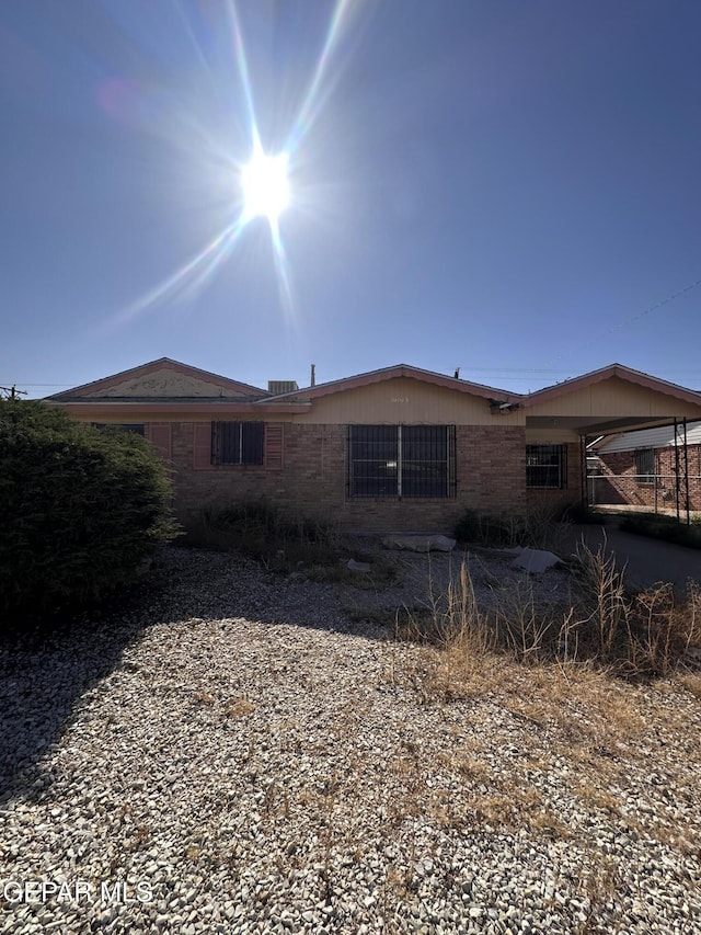 view of property exterior with an attached carport and brick siding