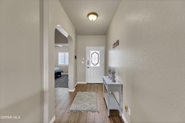 3841 Loma Adriana, El Paso, TX 79938 - foyer featuring a textured wall, arched walkways, wood finished floors, and baseboards