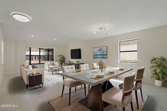 dining space featuring marble finish floor, baseboards, vaulted ceiling, and a textured ceiling