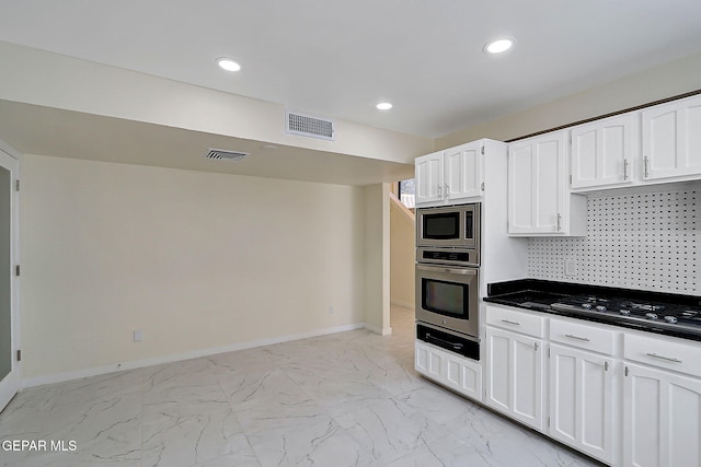 kitchen featuring white cabinetry, visible vents, marble finish floor, and stainless steel appliances