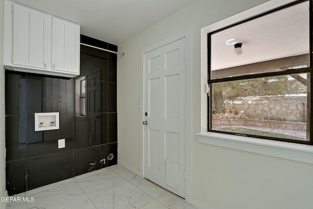 foyer with baseboards and marble finish floor