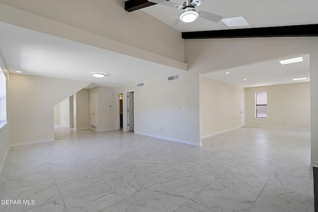 spare room featuring lofted ceiling, visible vents, baseboards, and ceiling fan