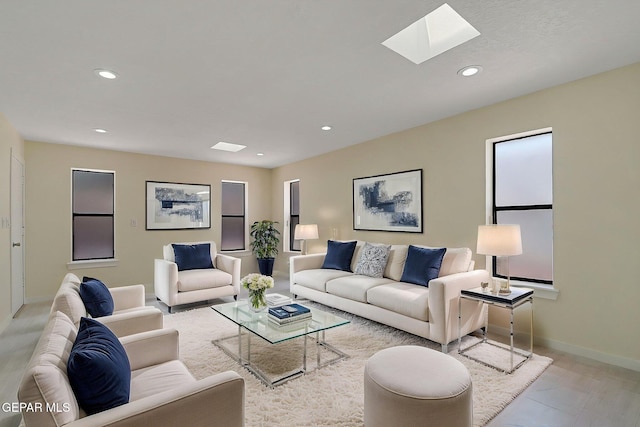 living area with recessed lighting, a skylight, and baseboards
