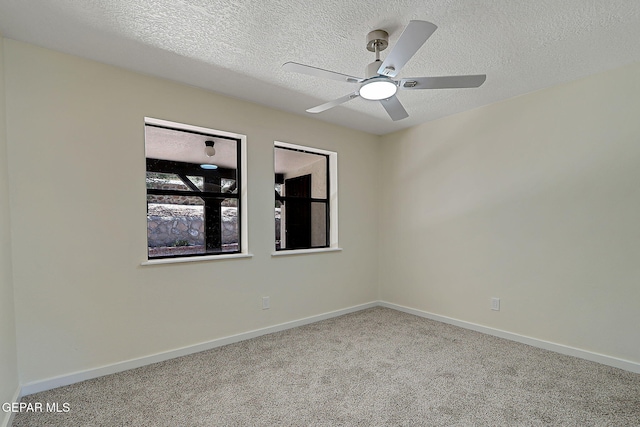 carpeted empty room featuring baseboards, a textured ceiling, and ceiling fan