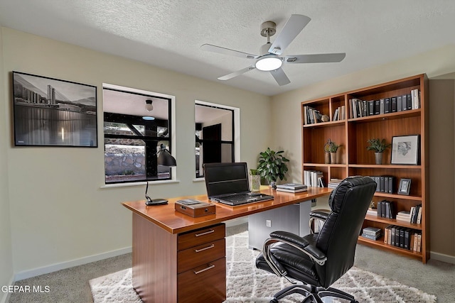 home office featuring baseboards, carpet, a textured ceiling, and ceiling fan