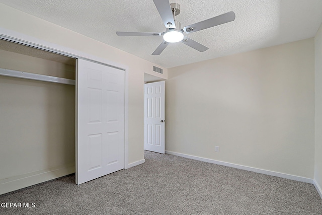 unfurnished bedroom featuring baseboards, a textured ceiling, visible vents, and carpet