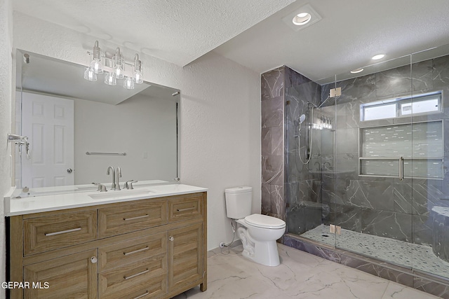 bathroom featuring marble finish floor, toilet, vanity, a textured ceiling, and a stall shower