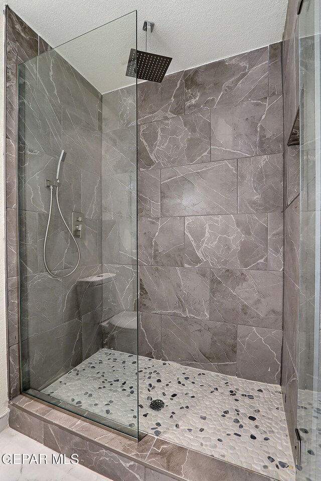 full bath featuring walk in shower and a textured ceiling