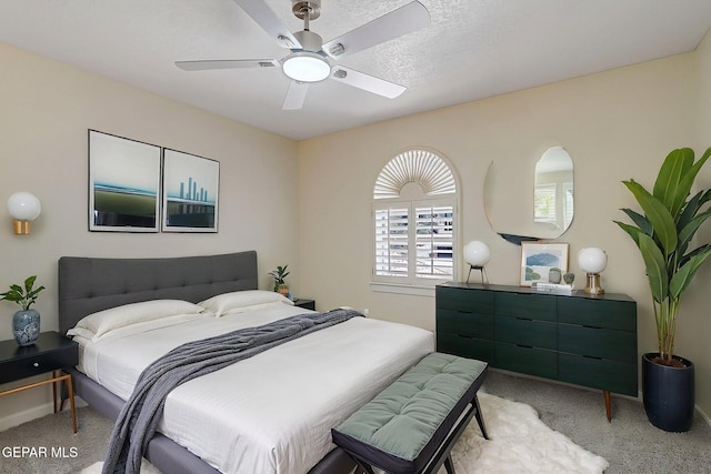 bedroom with light colored carpet, baseboards, and a ceiling fan