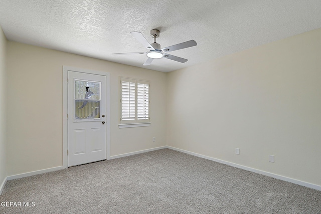 carpeted empty room featuring baseboards, a textured ceiling, and ceiling fan