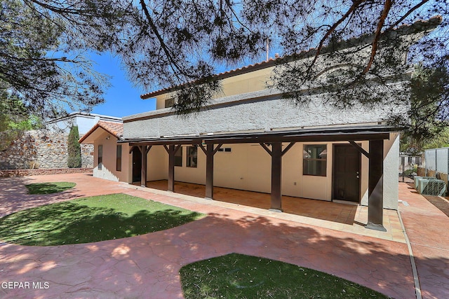 rear view of property with fence, a patio area, a tile roof, and stucco siding